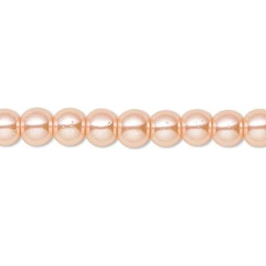 A strand of round, lustrous peach-pink pearls aligned horizontally against a plain white background.
