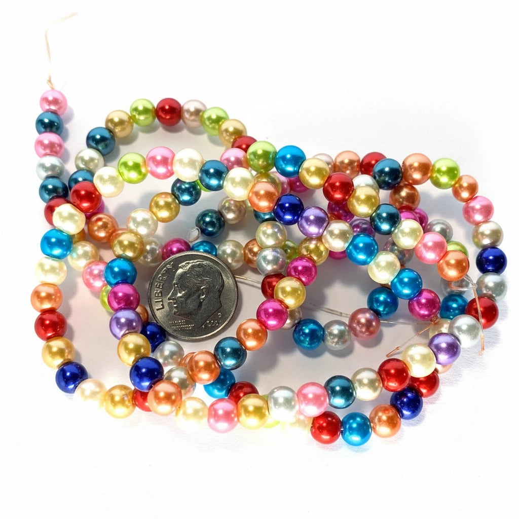 Multicolor glossy pearl beads on strands, shown with a US quarter coin for scale on a white background.