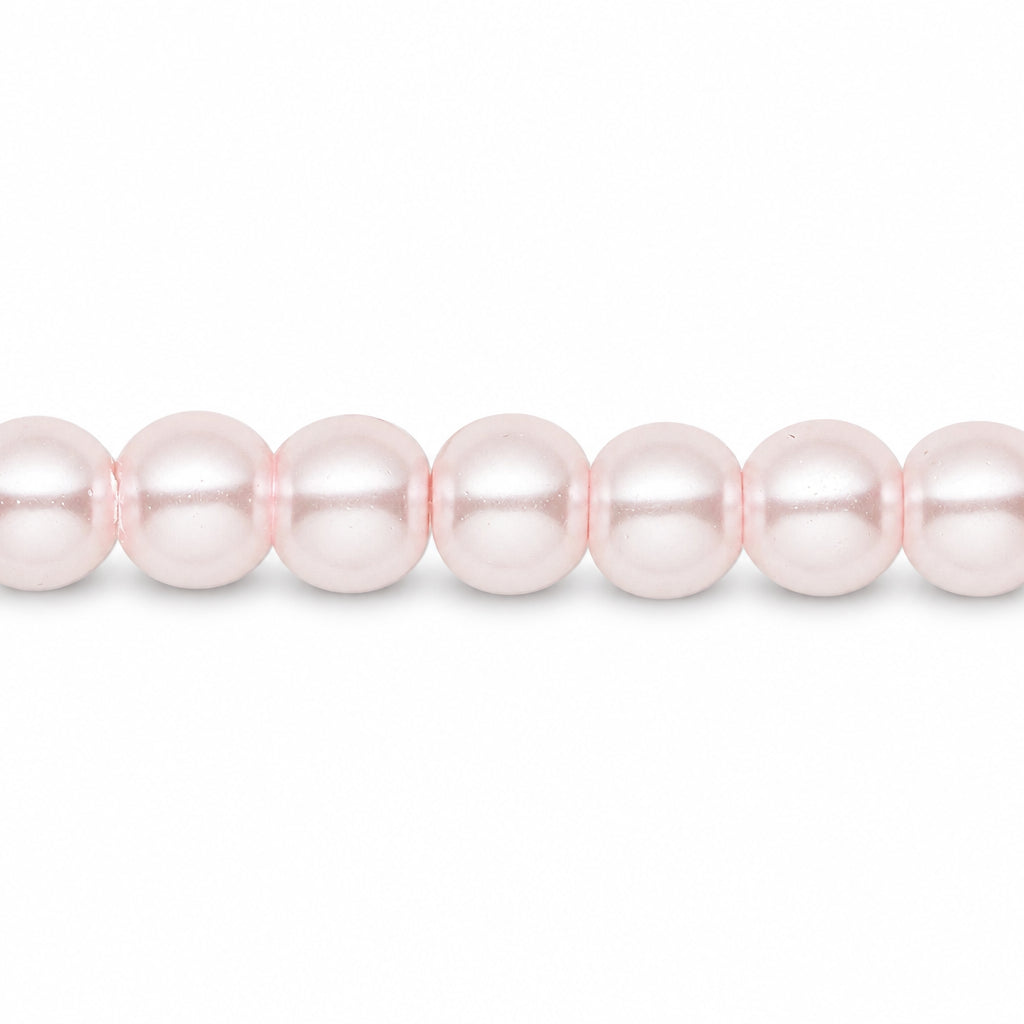 A close-up of a strand of pale pink glass pearls aligned horizontally against a solid white background.