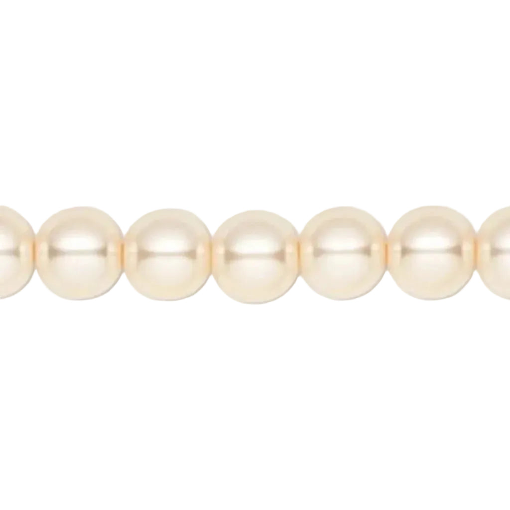A close-up of a strand of round, lustrous pearl-like beads in a warm cream or ivory tone against a plain white background.