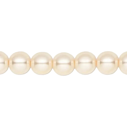 A close-up of a strand of round, lustrous pearl-like beads in a warm cream or ivory tone against a plain white background.