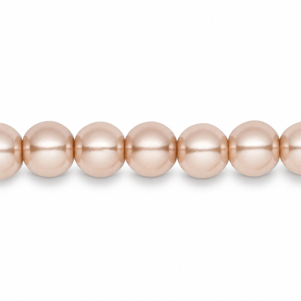A close-up of a strand of round, lustrous pearls in a soft champagne pink color, shown against a plain white background.