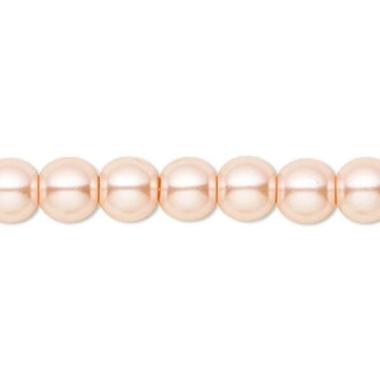 A close-up of a strand of round, glossy peach-pink beads on a plain white background.