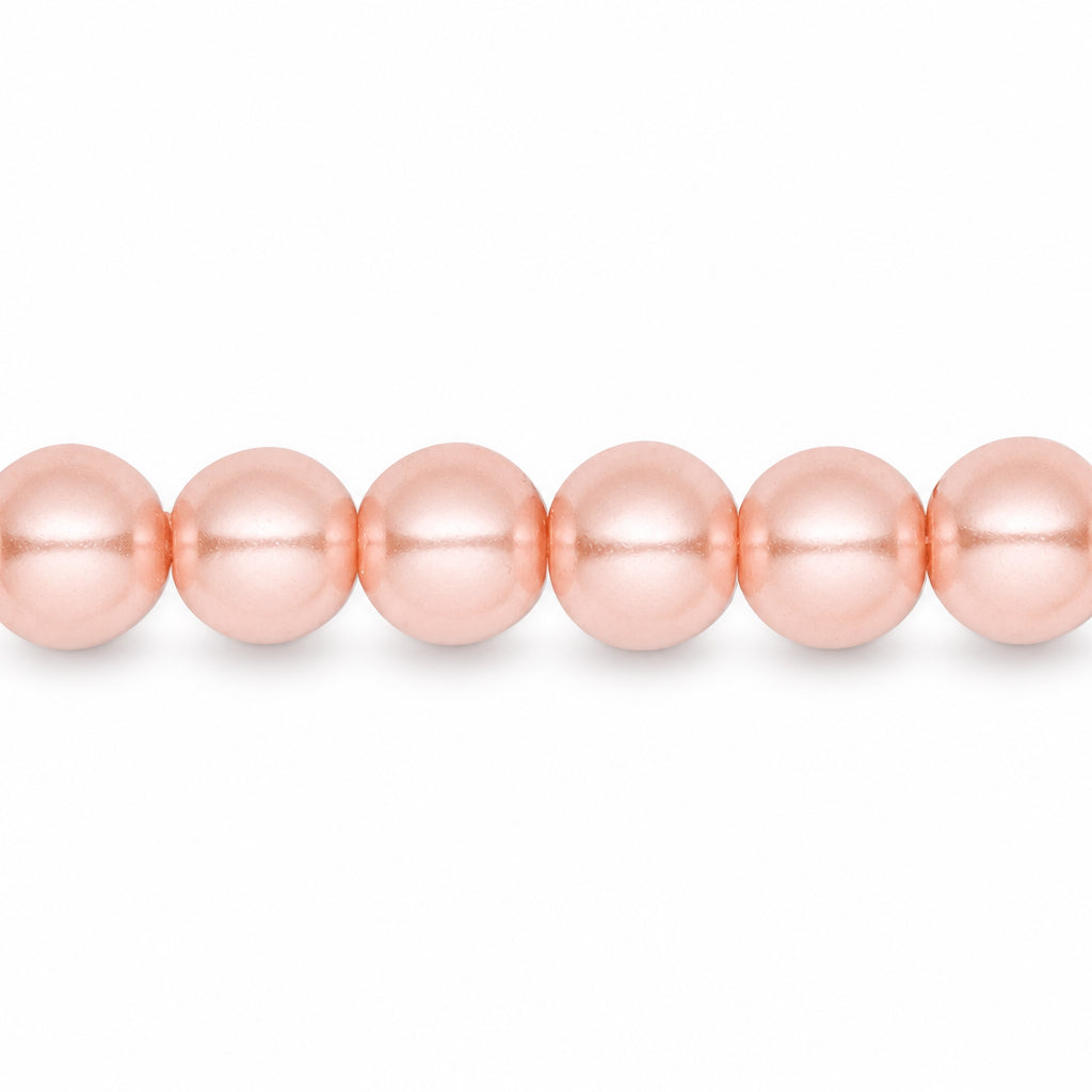 A close-up horizontal row of glossy, peach-pink round beads on a plain white background.