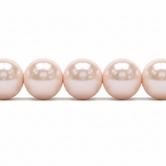 A close-up of a strand of round, lustrous pearl beads in a soft champagne-pink color, shown against a plain white background.