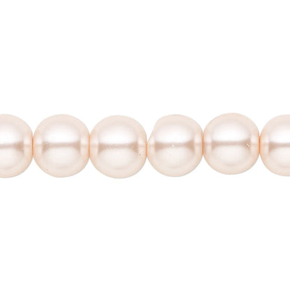 A close-up of a strand of round, lustrous pearl beads in a soft champagne-pink color, shown against a plain white background.