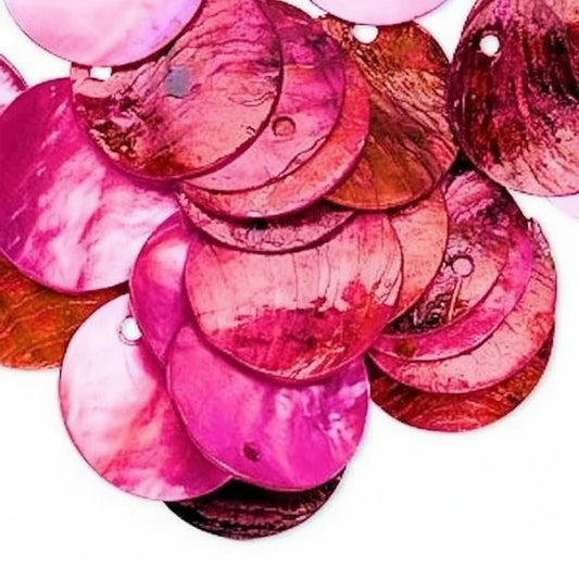A pile of round, glossy shell-like sequins in shades of pink, magenta, and reddish-brown, with small holes visible, photographed on a white background.