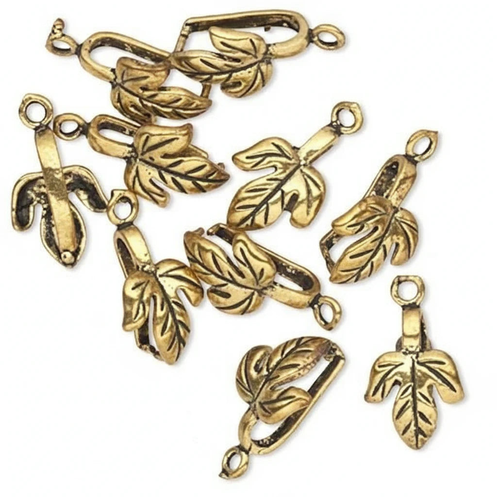 A set of antique gold leaf-shaped jewelry findings or charms with attached loops, arranged on a plain white background.