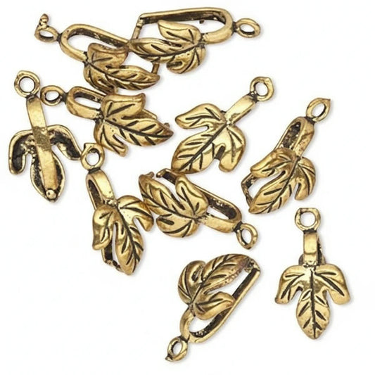 A set of antique gold leaf-shaped jewelry findings or charms with attached loops, arranged on a plain white background.