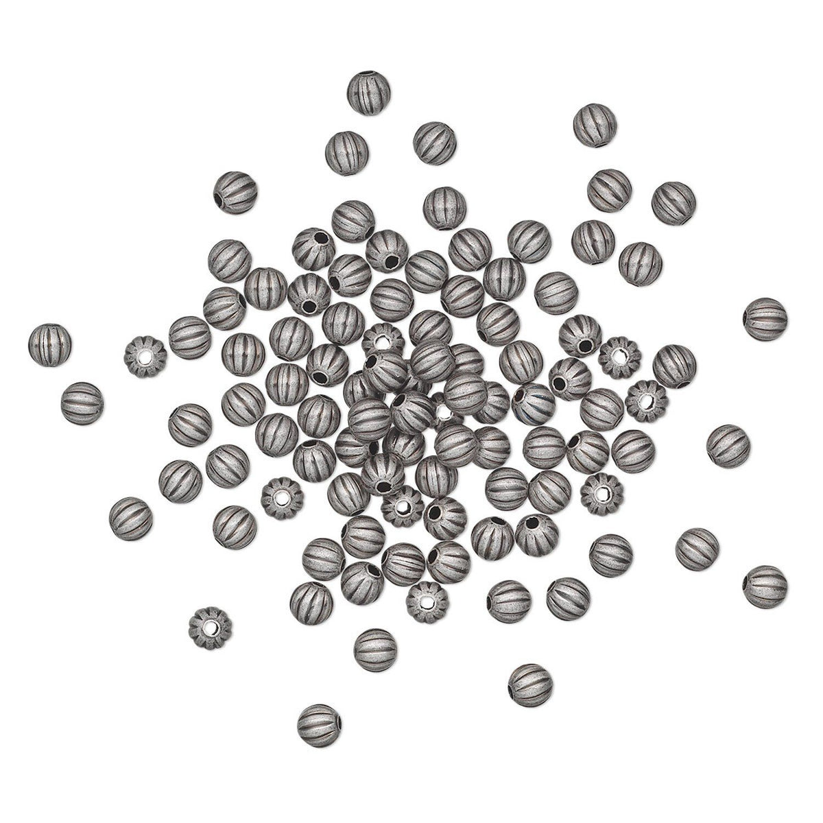 A pile of small metallic spacer beads scattered on a plain white background. The beads are silver-toned with dark gray engraved stripes and some have starburst details.