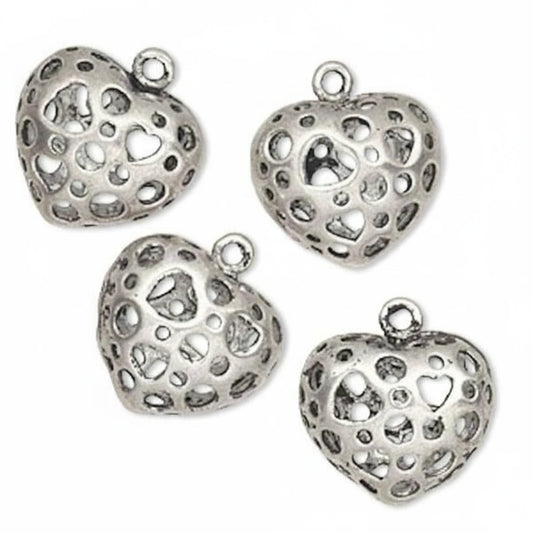 Four silver heart-shaped jewelry charms with intricate cutout patterns and small loops at the top, displayed on a clean white background.