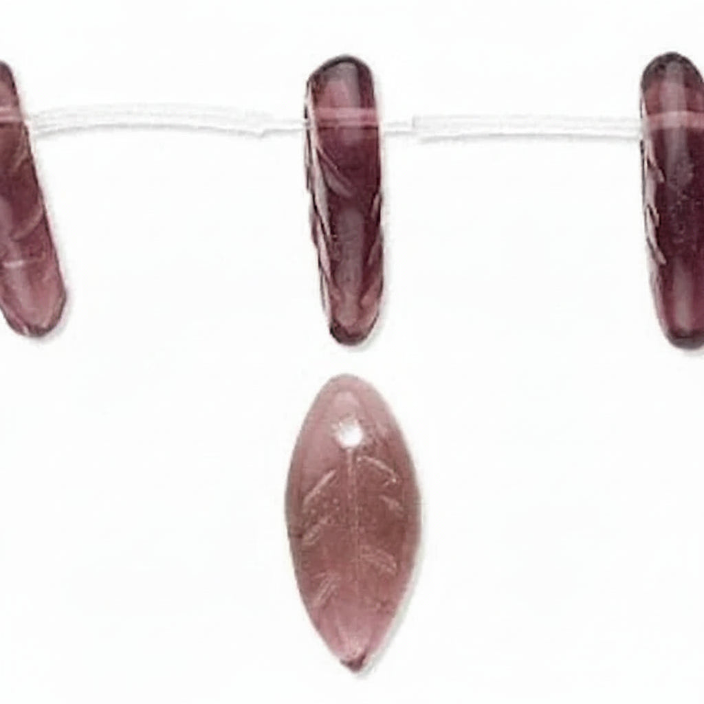 A close-up of faceted oval beads strung on a clear cord, showing a dusty rose pink color with subtle leaf engravings, set against a plain white background.