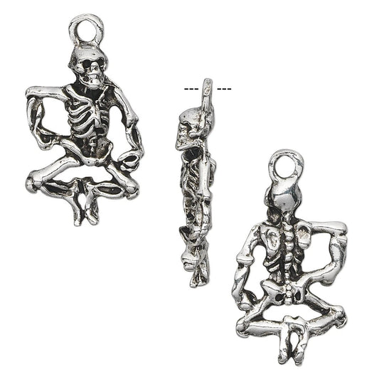 Three views of a silver-toned metal skeleton pendant charm shown on a plain white background, including front, side, and back angles.
