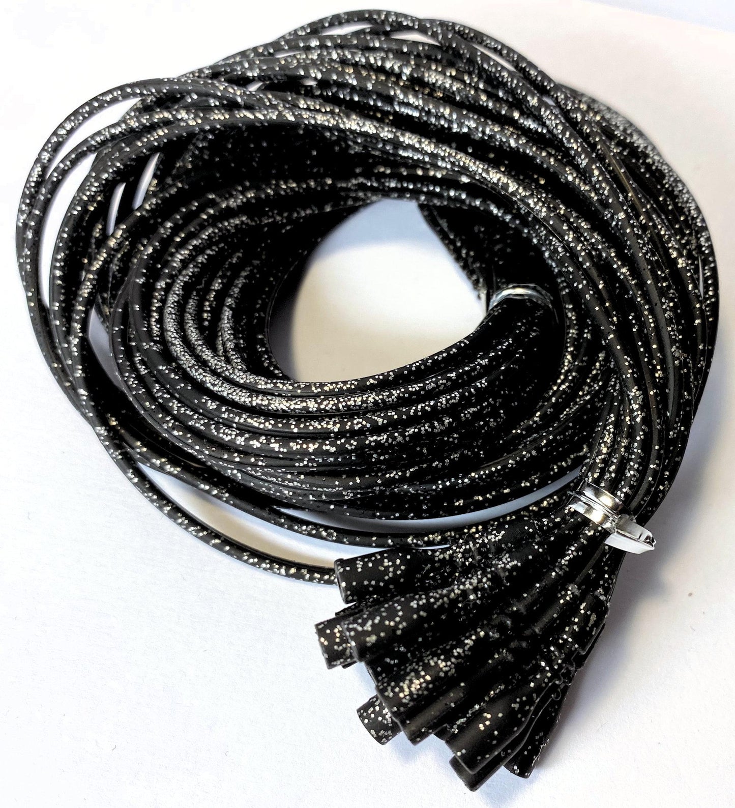 Coiled black glittery cords on a white background