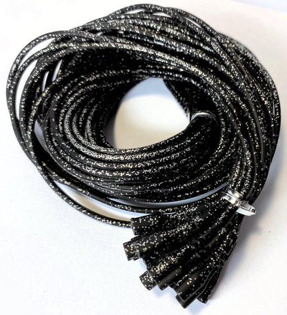 Coiled black glittery cords on a white background