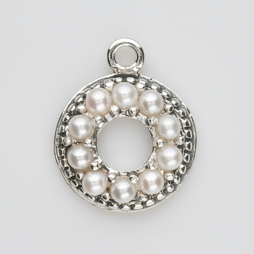A sterling silver circular pendant charm featuring a halo of small white pearls around a central open circle, with a top loop for attachment, shown on a plain white background.