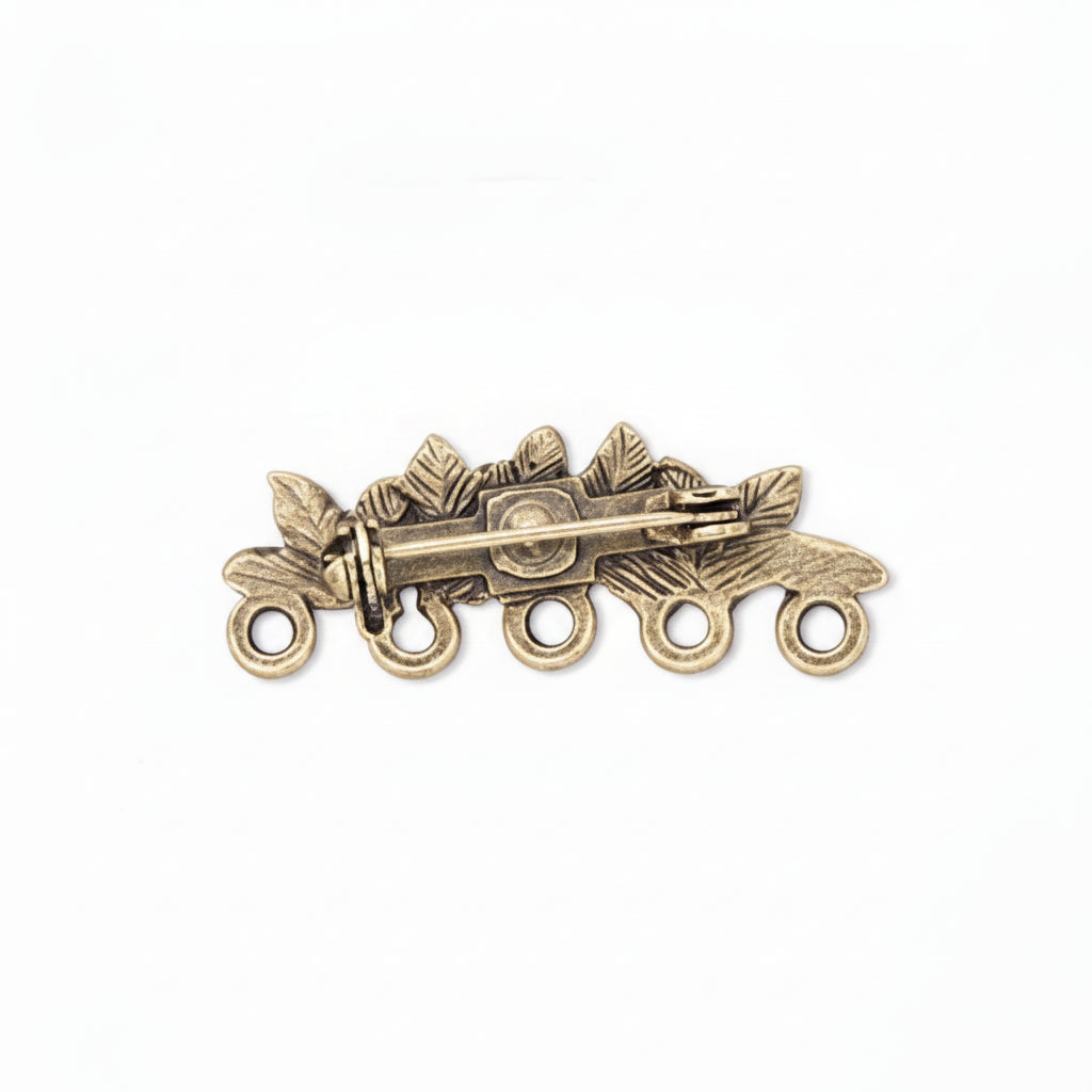An antique bronze-toned metal brooch shown from three angles: front view with leaf and berry motifs and five hanging loops, side view showing the pin clasp mechanism, and back view with the pin stem and clasp visible.