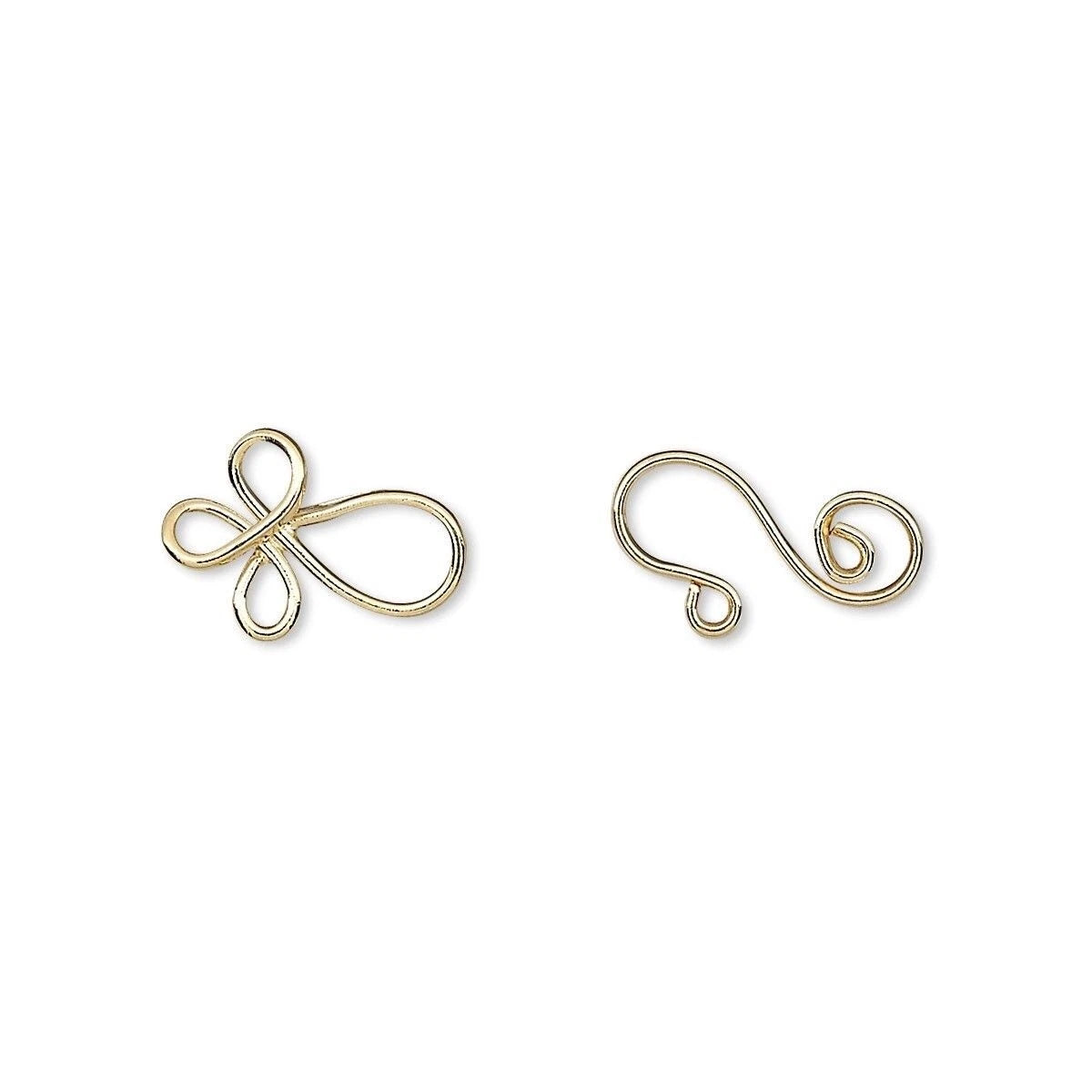 Two small gold metal wire findings, one shaped like a stylized infinity symbol and the other like a curled tail piece, shown on a plain white background.