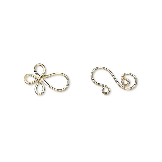 Two small gold metal wire findings, one shaped like a stylized infinity symbol and the other like a curled tail piece, shown on a plain white background.