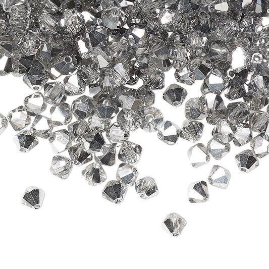 A pile of clear faceted crystal beads scattered on a white background, with a few beads lying outside the pile.