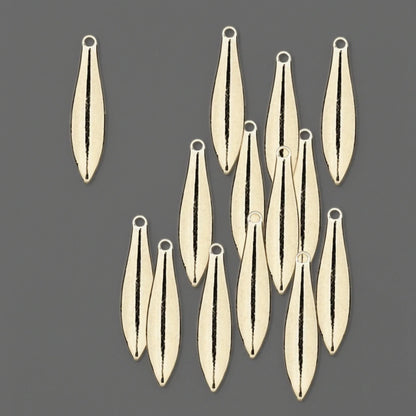 A set of small teardrop-shaped metal charms with a central cutout, arranged on a solid dark gray background.