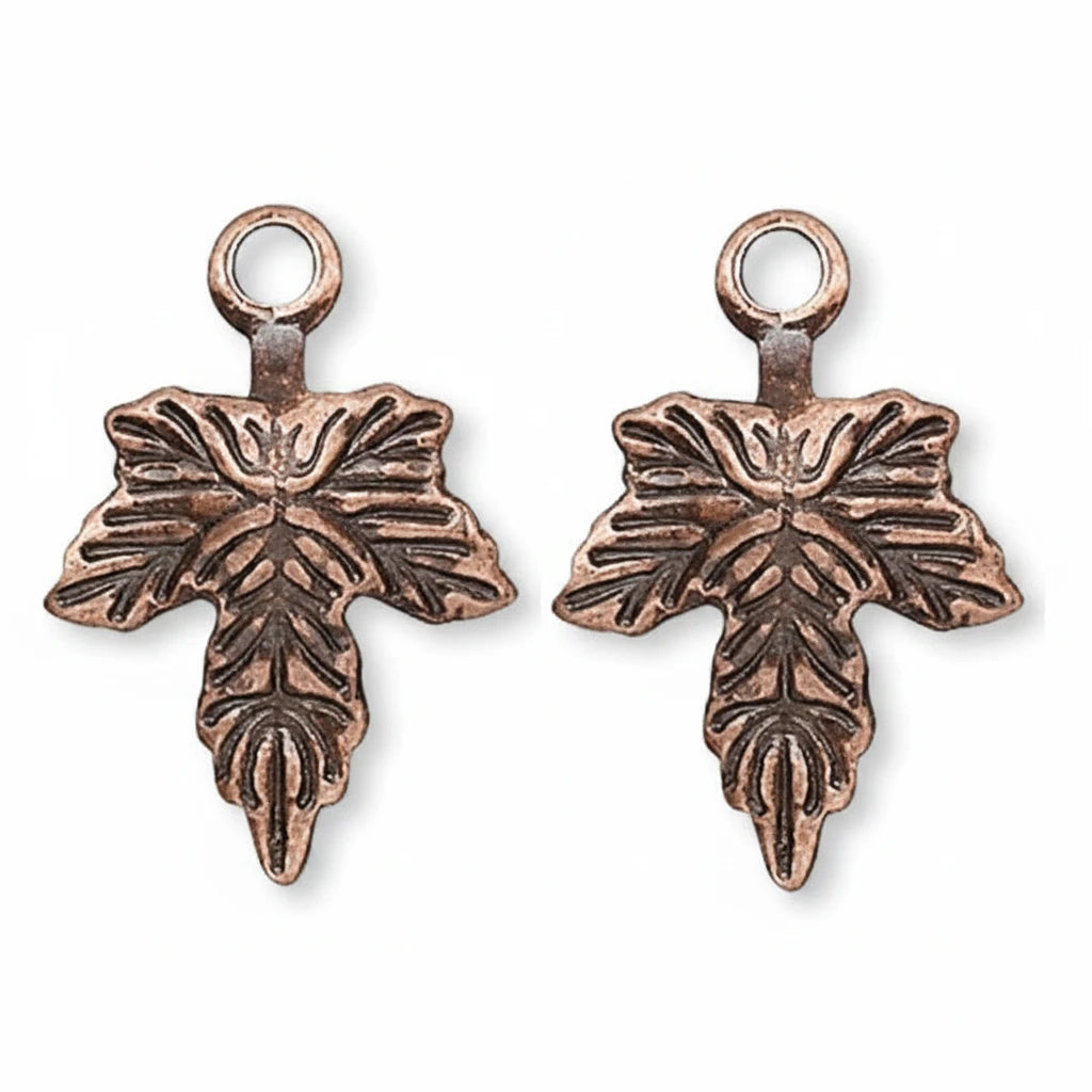 Two antique bronze cross charms with leaf-like embossed details and hanging loops, shown on a plain white background.