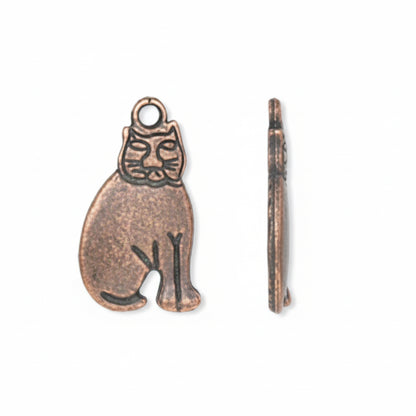 An antique bronze-toned metal charm shaped like a seated figure with a loop at the top, shown next to a narrow side profile view on a plain white background.