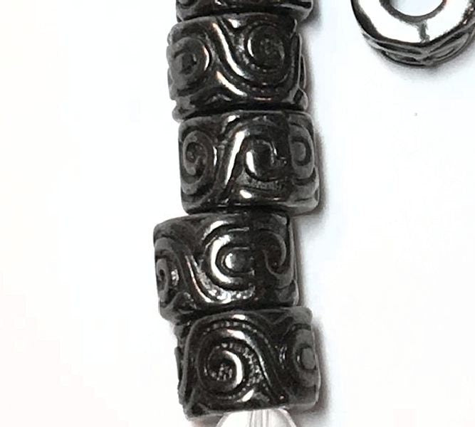 Close-up of decorative beads with intricate patterns on a white background