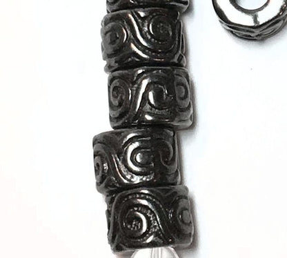 Close-up of decorative beads with intricate patterns on a white background