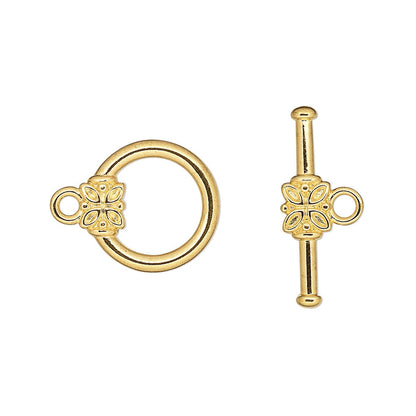 Gold ring and key-shaped object on a white background