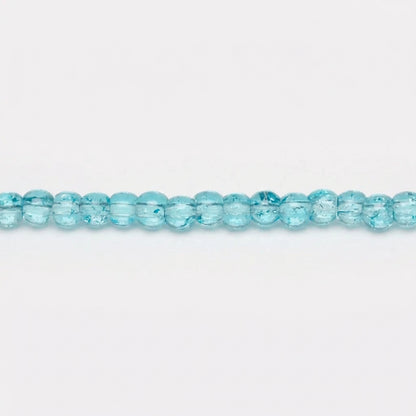 Light blue faceted glass beads shown as a strand with a circular close-up inset highlighting their transparent, bubbly texture.
