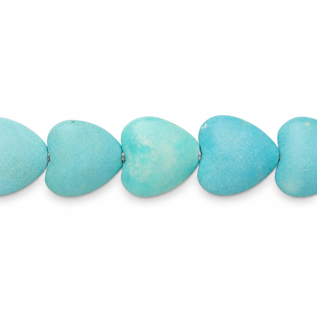 A close-up of a strand of heart-shaped turquoise beads on a plain white background.