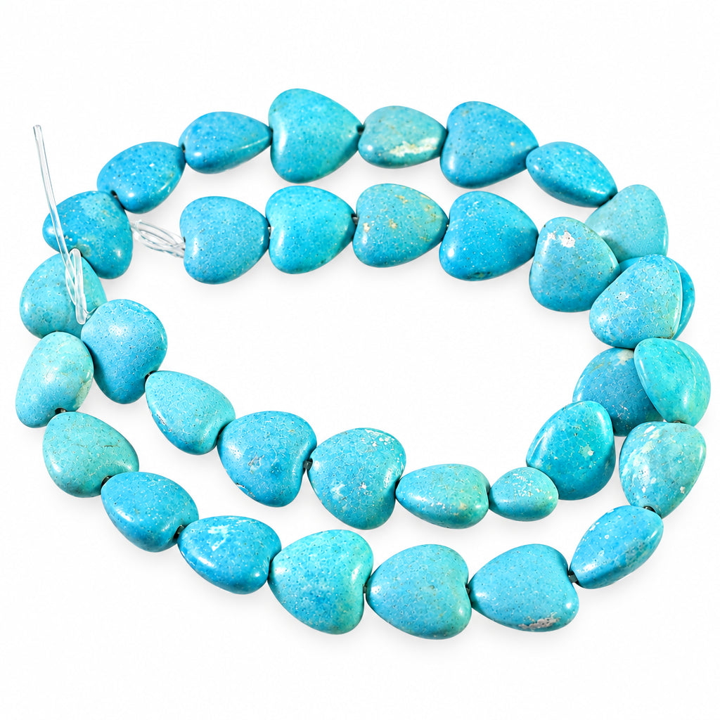 A strand of heart-shaped turquoise beads on a plain light gray background.
