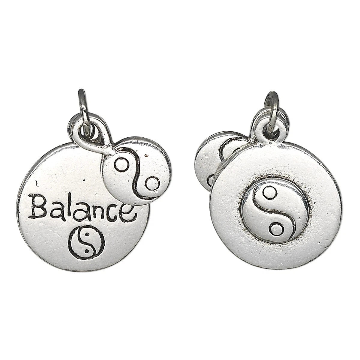 Two silver-toned round charm pendants on a white background, each with a small dangling yin-yang charm and a top loop. One pendant is engraved with the word 'Balance' and a yin-yang symbol, and the other shows a raised yin-yang symbol.