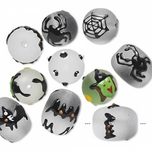 A set of round glass beads with a white base, decorated with various Halloween-themed illustrations including spiders, webs, bats, a spider on a door, a witch, and a cat.