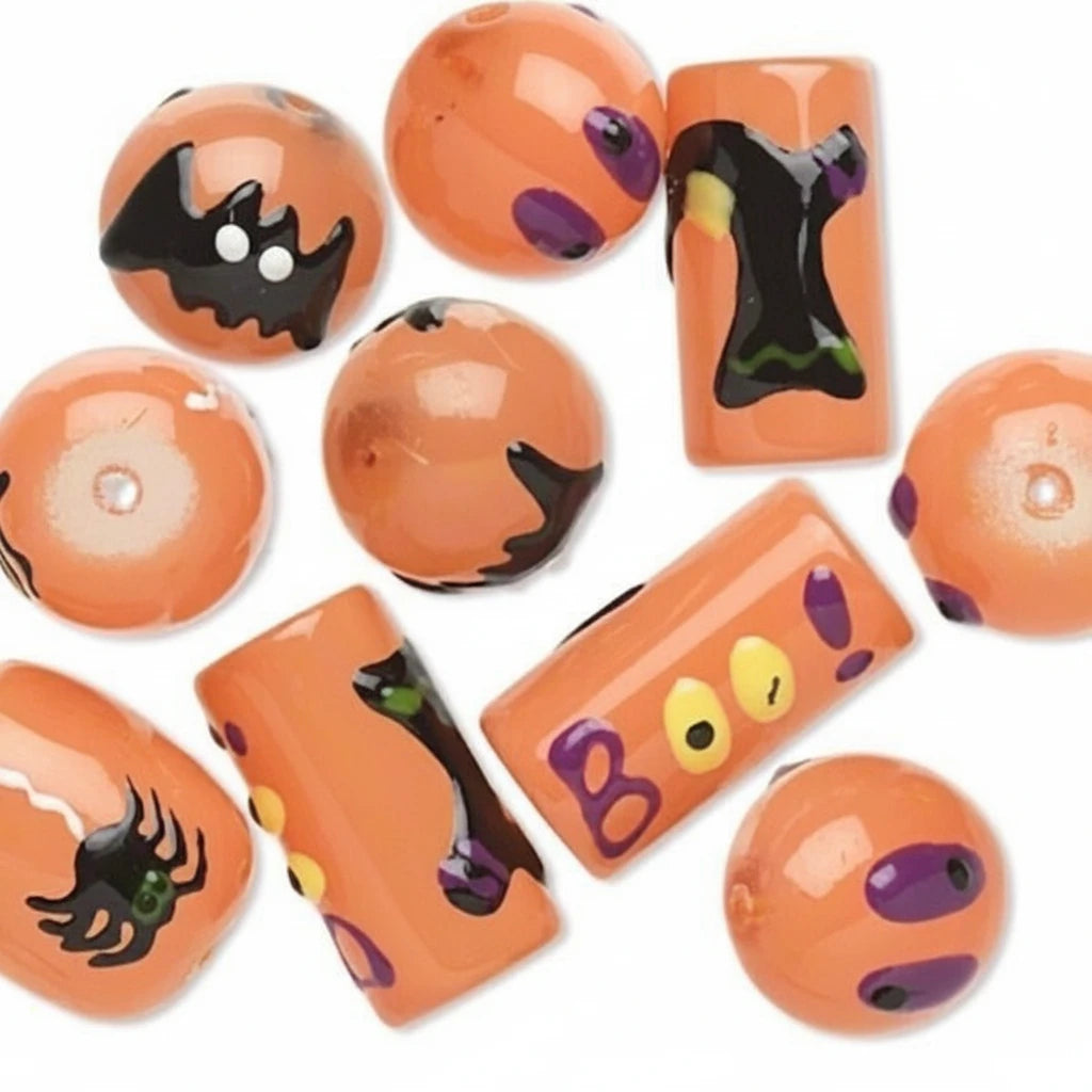 A set of orange Halloween-themed glass beads with black spider, bat, and ghost designs, along with purple and yellow accents, arranged on a white background.