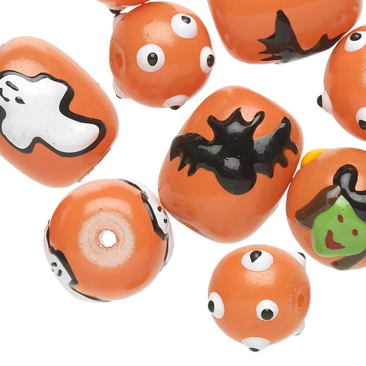 A group of orange Halloween-themed glass beads with various spooky designs including a white ghost, black bat, witch face, and cartoon eyes, shown on a white background.