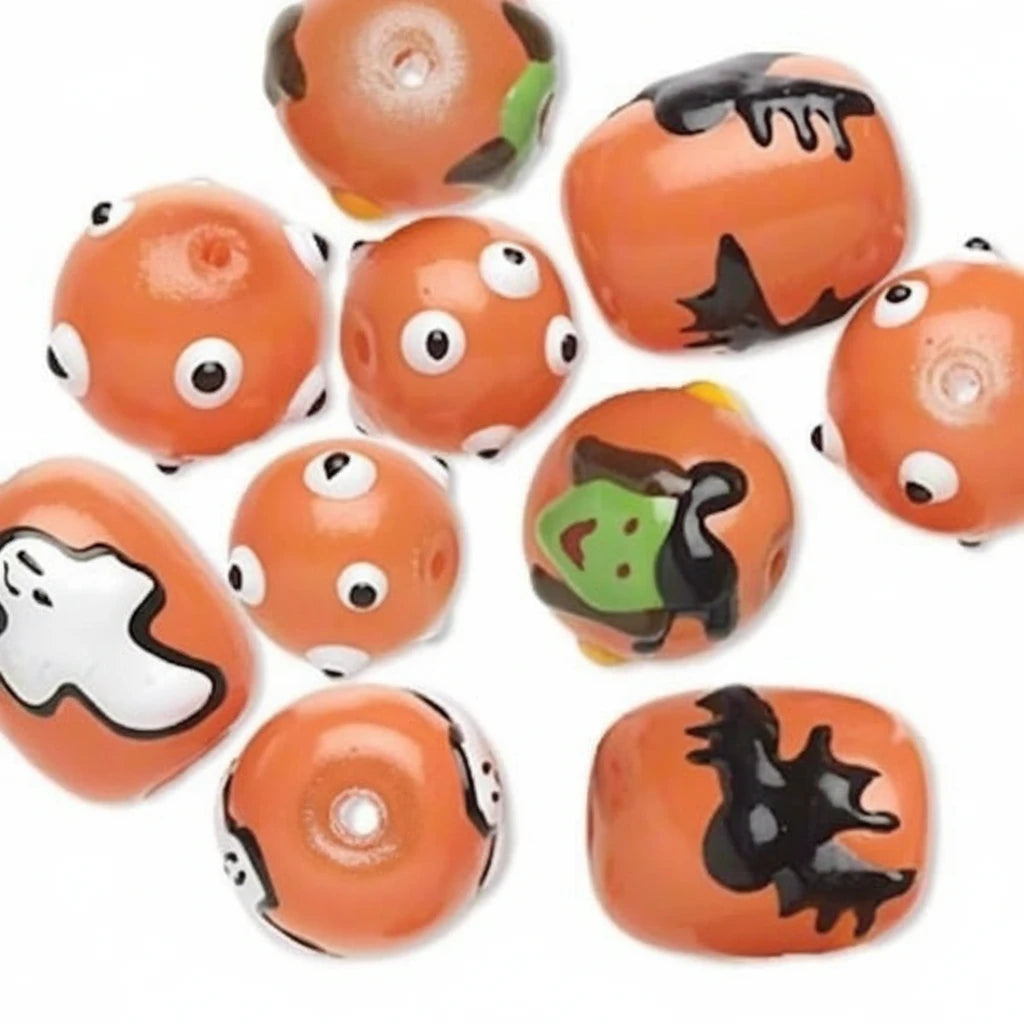 A set of orange Halloween-themed glass beads with various painted designs including ghoulish faces, a ghost, a witch's hat, and a black bat silhouette.