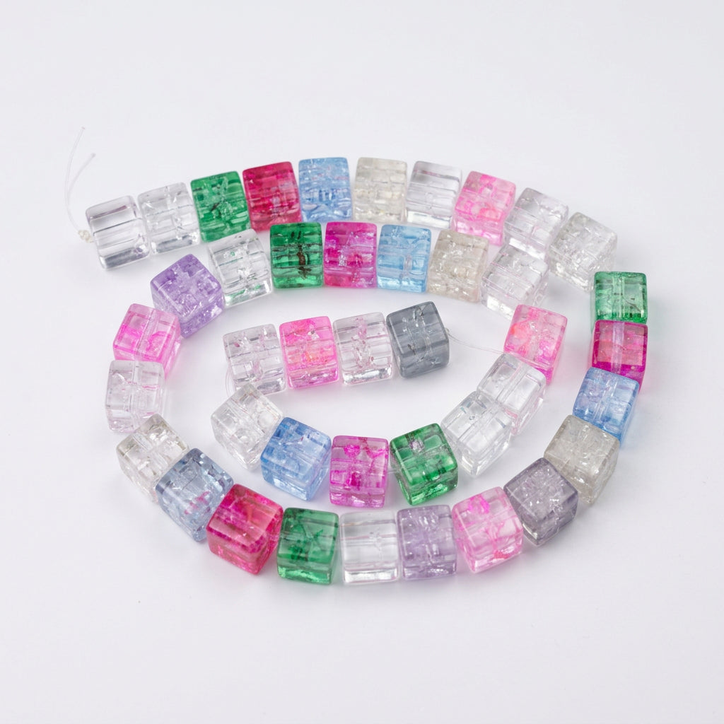 A coiled strand of GLASS beads with  pink, green, blue, and purple, arranged on a white sheet of paper.