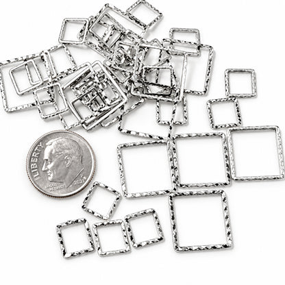 A pile of small square metal frames with jagged, hammered edges in a silver-tone finish, shown on a white background with a US quarter coin for scale.
