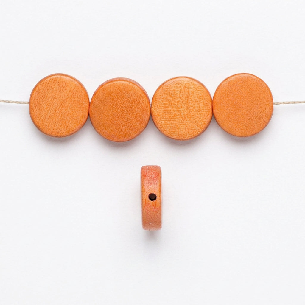 Orange round wooden beads shown in a row with one bead displayed vertically to show its thickness and a hole for stringing, on a plain white background.