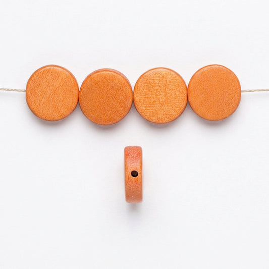 Orange round wooden beads shown in a row with one bead displayed vertically to show its thickness and a hole for stringing, on a plain white background.