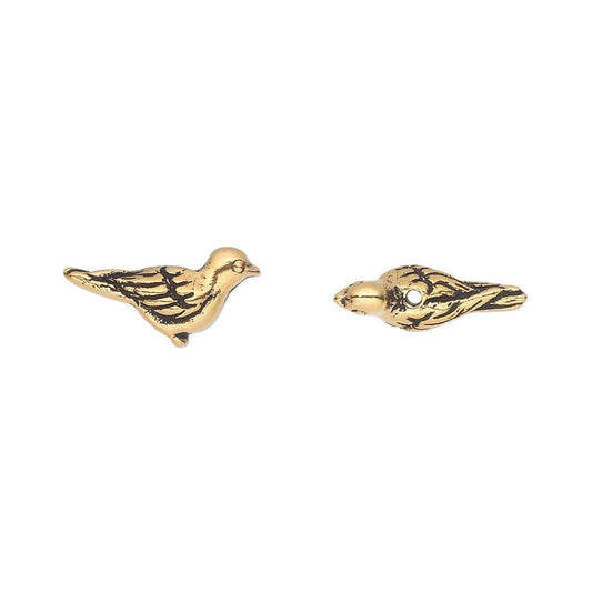 A pair of gold bird stud earrings with dark antiqued detailing and a small clear stone on one earring, shown on a plain white background.