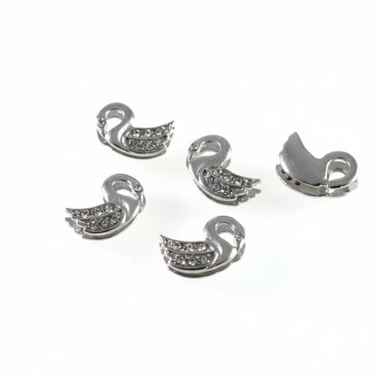Five silver-toned swan-shaped jewelry findings or charms with small clear rhinestones, shown on a plain white background from both front and back views.