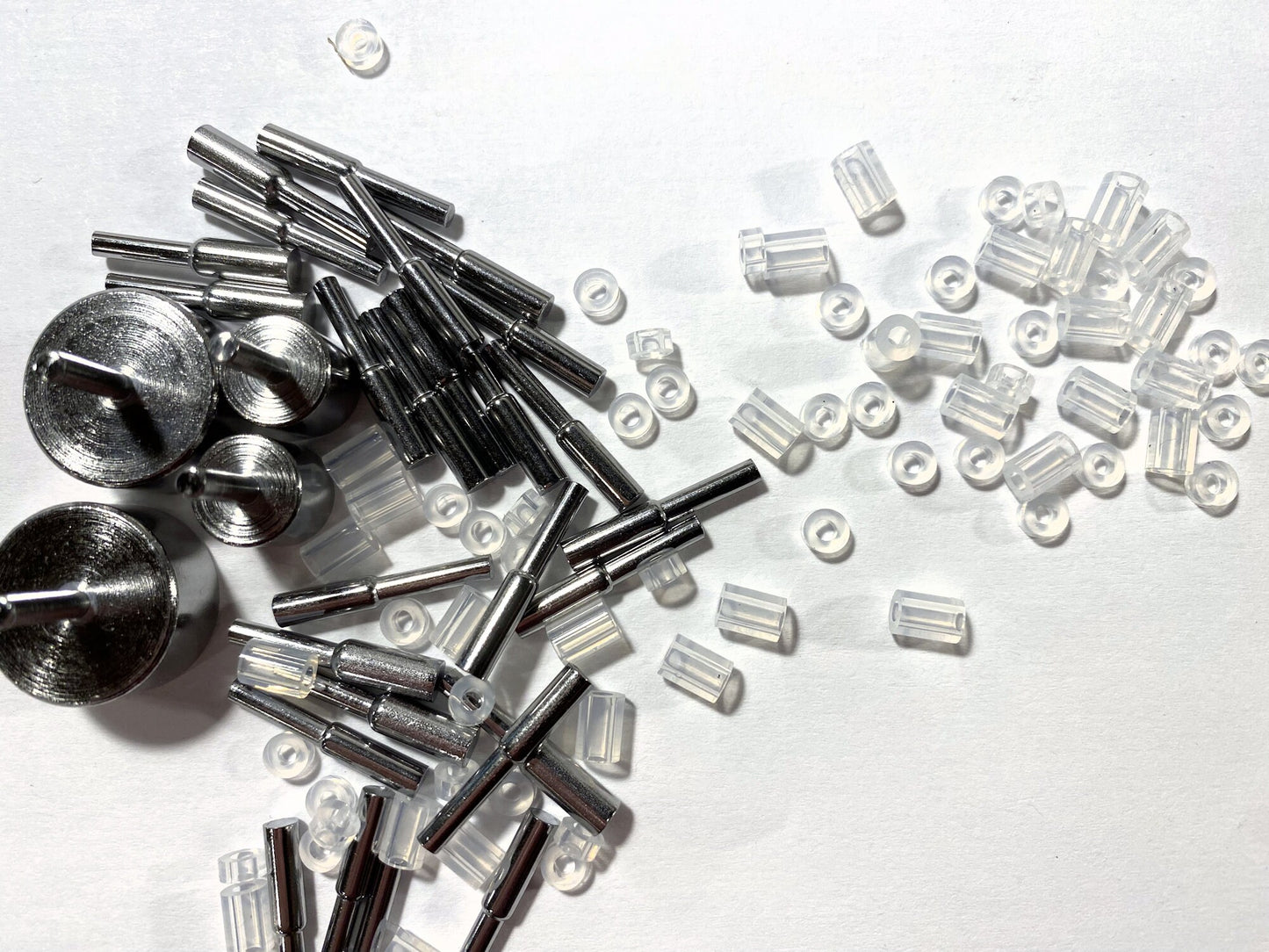 Collection of metal and clear plastic components on a white background