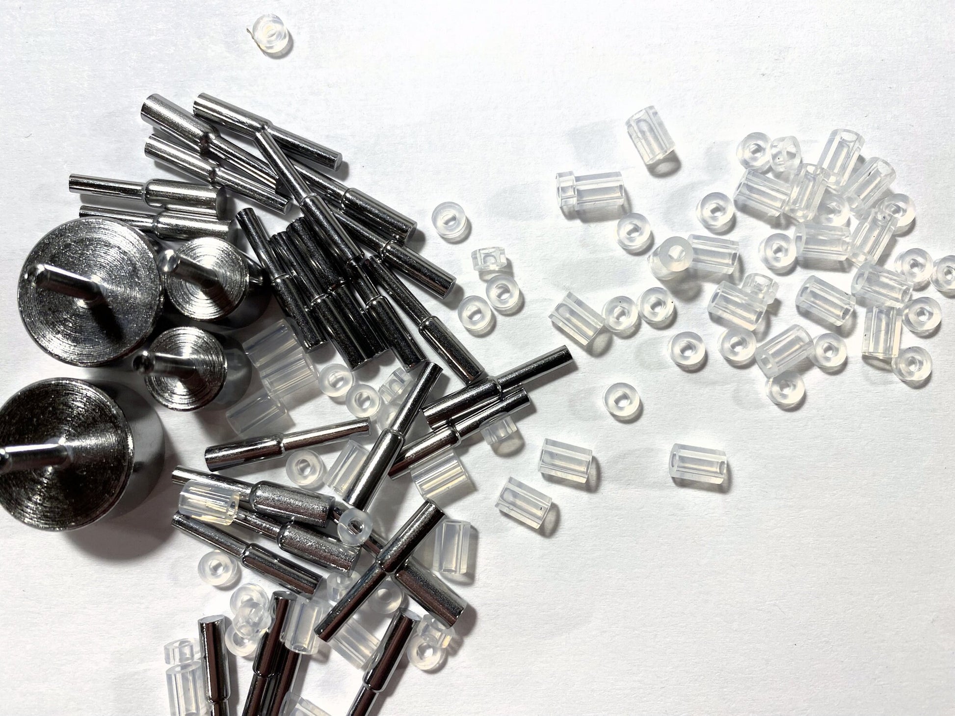 Collection of metal and clear plastic components on a white background