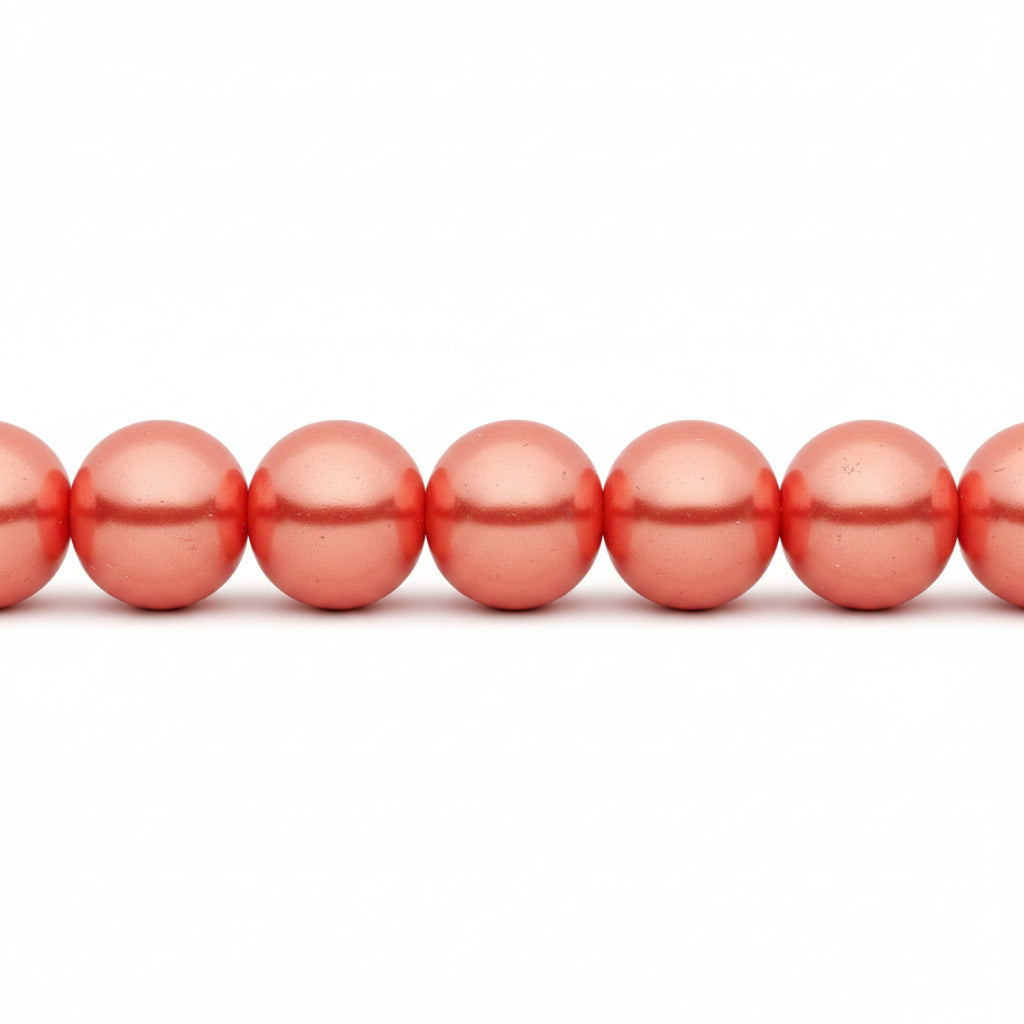 A close-up of glossy, metallic coral-pink round beads strung horizontally on a white background.