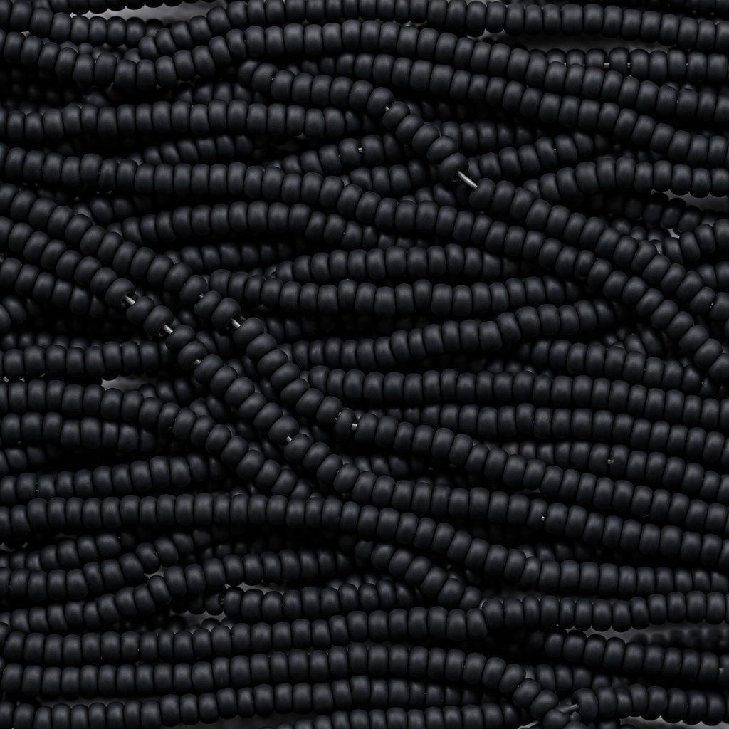 A close-up of many small dark beads strung together in dense horizontal rows, filling the entire frame.
