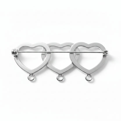 A silver-toned metal pin featuring three interlocking open heart shapes outlined with small sparkling rhinestone-like details, shown on a plain light background.