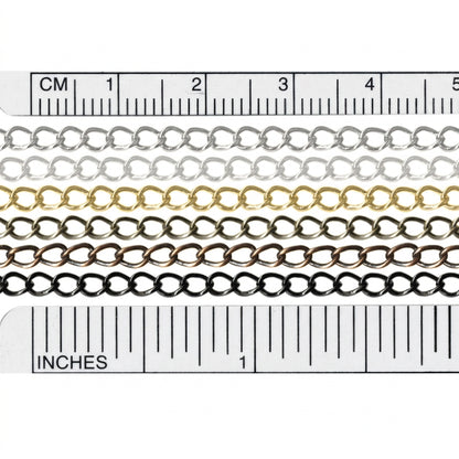 Four metal chain strands in silver, gold, bronze, and black, shown in a close-up with ruler markings above and below for centimeter and inch measurements.
